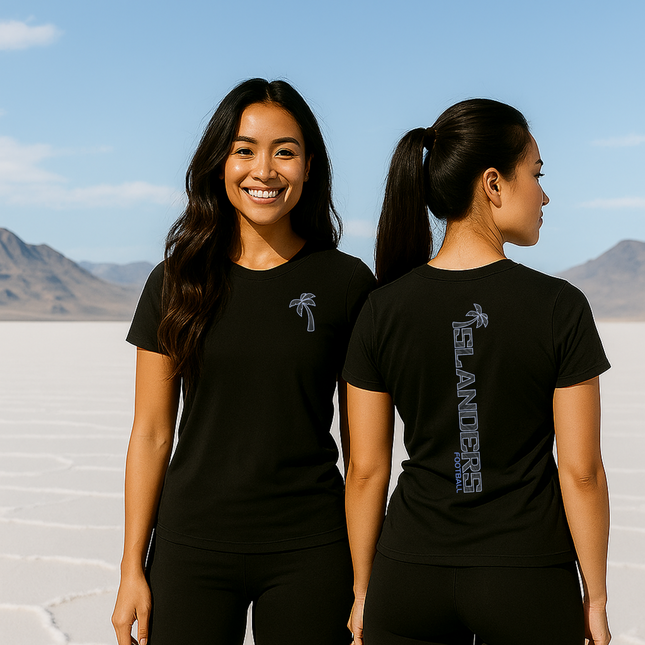 Woman wearing a black t-shirt with a palm tree design on the front and text on the back, standing against a desert landscape.